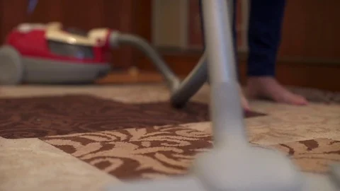 Close up of the vacuum cleaner, focus on the brush, woman cleaning the carpet Stock Footage 74699506