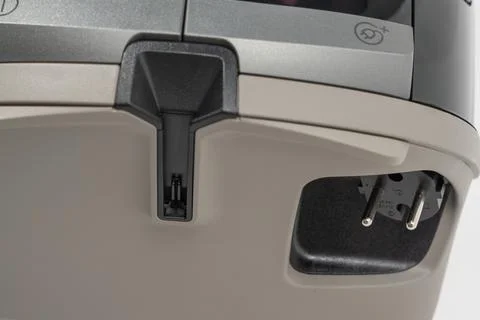 Close-up of a vacuum cleaner power plug and cable storage compartment with Stock Photos