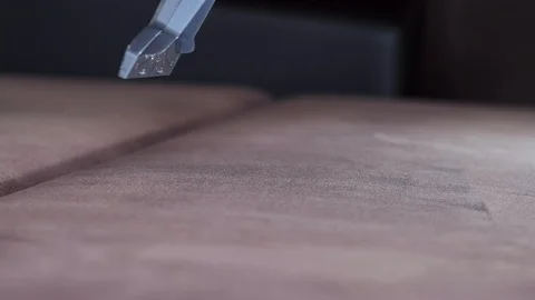 Close-up vacuum cleaner sprays detergent onto sofa Stock-Footage 122077515