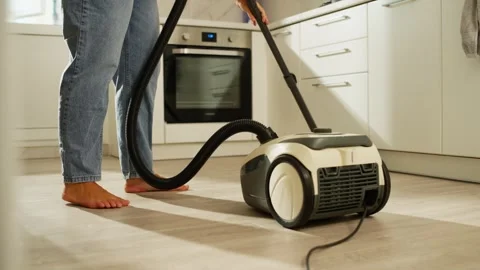 Close-up of a vacuum cleaner in a woman's hands cleaning the kitchen. Stock Footage 282285167