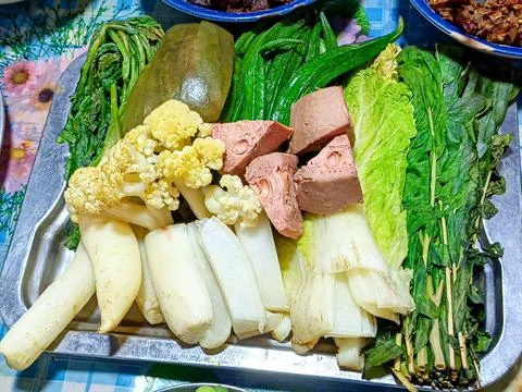Close-up of various boiled vegetables placed in a stainless steel tray. Foto stock