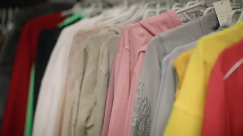 Close up various colored clothing items hanging on rack showing different Stock Footage 346730916