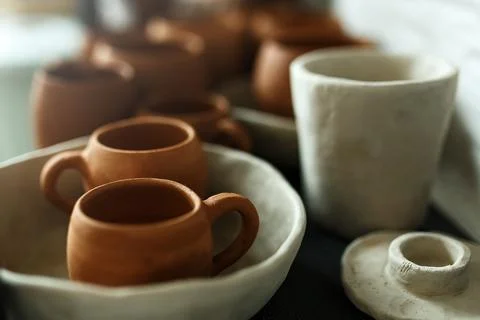 A close-up of various drying clay tableware on a shelf. A pottery studio concept Stock Photos