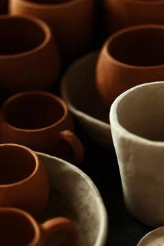 A close-up of various drying clay tableware on a shelf. A pottery studio concept Stock Photos