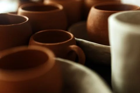 A close-up of various drying clay tableware on a shelf. A pottery studio concept Stock Photos