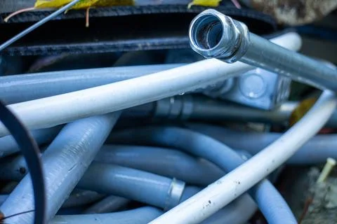 Close up of various electrical conduits and industrial pipes in a pile 库存照片