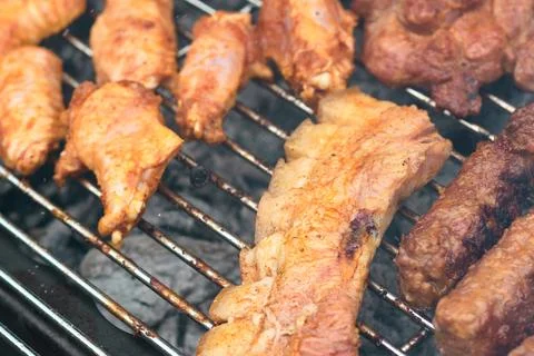 Close-up of various meat cuts and traditional sausages grilling on hot coals Stock Photos