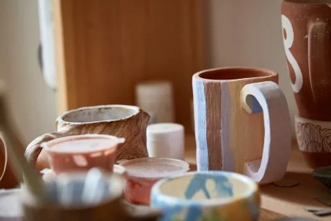 Close-up of various paint mugs and brushes in holder on worktop, selective focus Stock Photos
