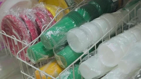 A close-up of various paper cups, plastic plates, colorful party supplies, and Stock Footage 321754371