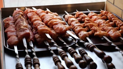 Close-up of various types of kebabs and meat snacks on skewers before cooking. Stock Footage 319004094
