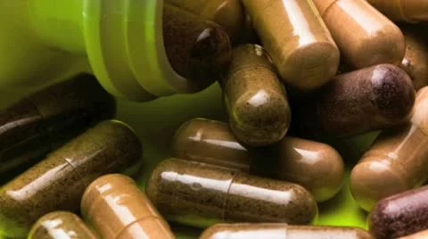 Close of various vitamin capsules spilled from a bottle Vídeos de archivo 21314565