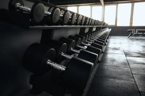 Close up of various weights dumbbells in the row are stored on a sturdy metal Stock Photos