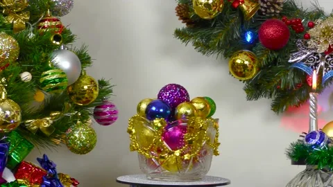 Close up of vase with balls between burning candles and christmas tree Stock Footage 201014555