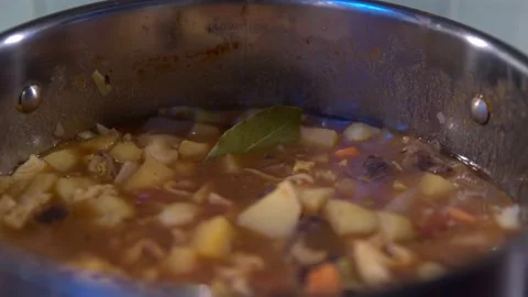 Close up of Vegetable soup cooking in pot on kitchen hob. Video stock 146025066