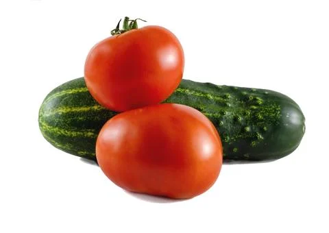 Close-up of vegetables: two tomatoes and a cucumber on a white background. Stock Photos