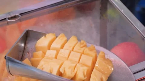 Close-Up of Vendor Hands Slicing Fresh Pineapple in Metal Scoop at Food Stall Stock Footage 345650724