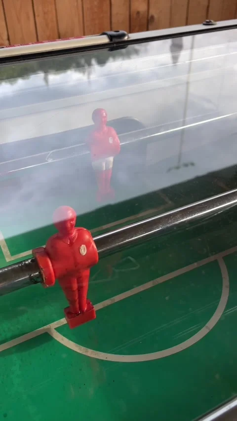 Close-up vertical foosball table rod with red player and acrylic splash guard 库存影片 341671429