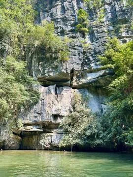 Close up of a vertical limestone cliff by the river in Tam Coc, Ninh Binh. Stock Photos