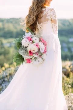 The close-up vertical portrait of the back of bride dressed in the long wedding Stock Photos