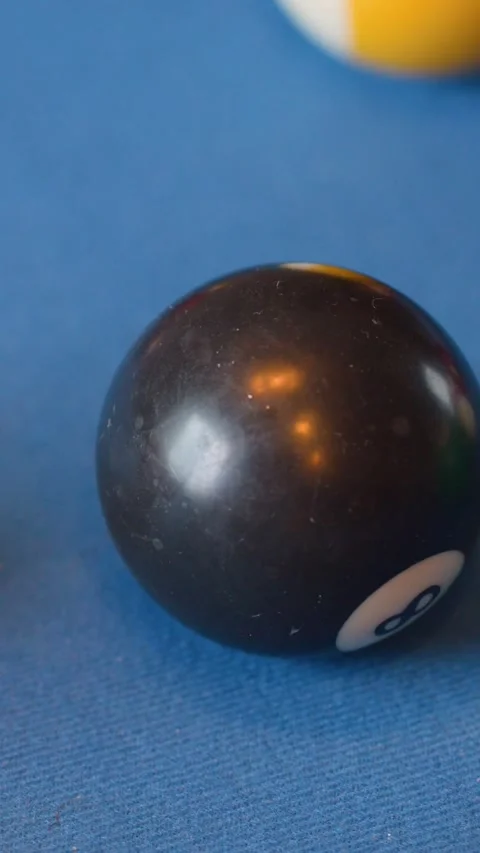 Close Up Vertical Shot of Eight Ball Rolling on Blue Felt Vídeo Stock 329466076