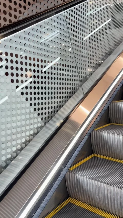 Close-Up Vertical Shot of Escalator Steps Moving Up Beside Modern Metal Wall Stock Footage 342351570