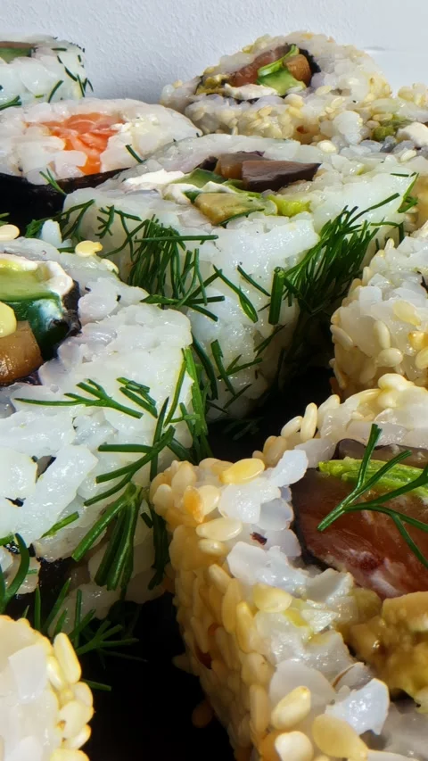 Close-up vertical social ratio video of various sushi dishes. Wasabi is poured Видео 336946079