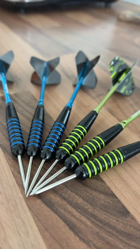 Close Up Vertical Video of Darts Grouped Together on Wooden Table Stock Footage 337506504