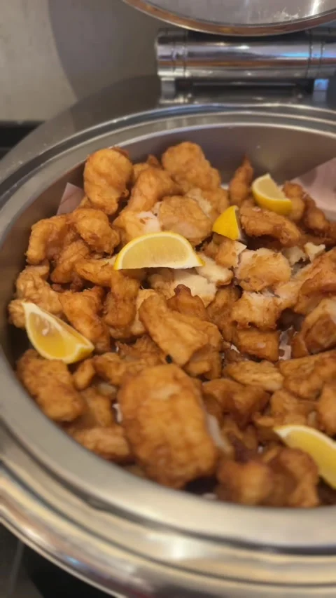 Close-up vertical video of golden fish fritters with lemon wedges Stock Footage 322967567