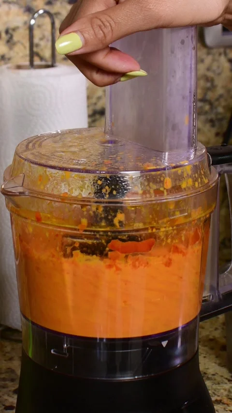 Close-Up Vertical Video of Hand Processing Red Ajies in Kitchen Blender Stock Footage 329556556