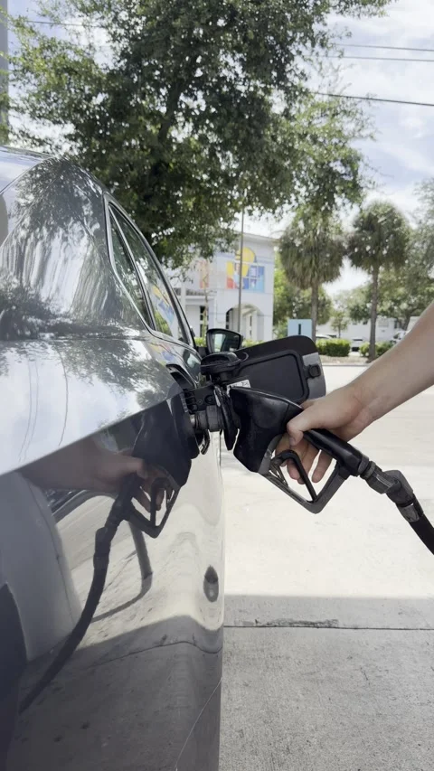 Close up vertical video of a hand removing a gas pump nozzle from a car, alt Stock Footage 343670440