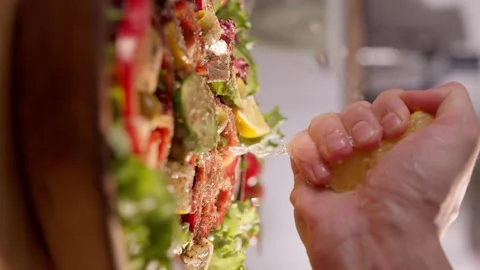 Close-Up Vertical video of a Mediterranean Salad with Fresh Vegetables as Lemon Stock Footage 293756311