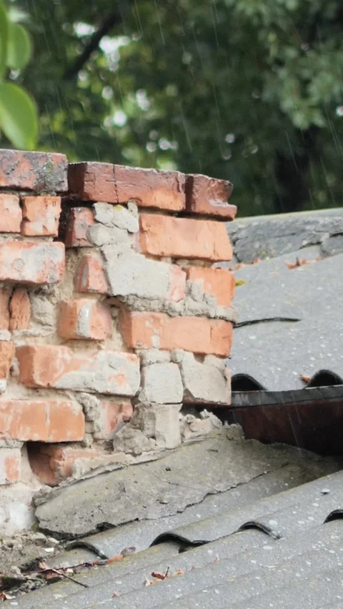 Close-up vertical video of raindrops pouring over an aged weathered brick ch Stock Footage 343063194