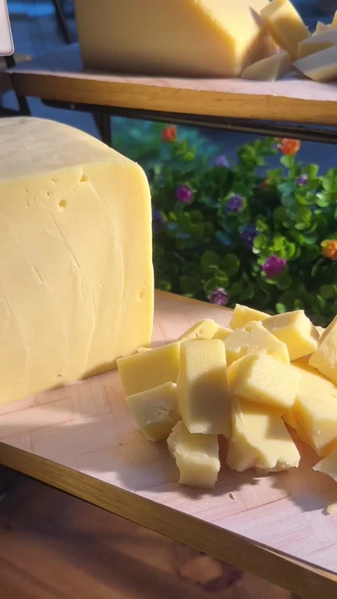 Close-up vertical video of yellow cheese block with sliced cubes Stock Footage 322967482