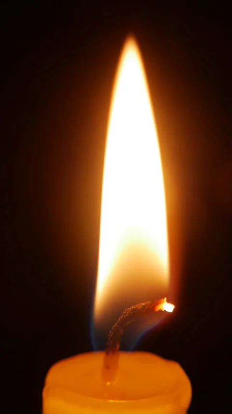 A close vertical view of a candle flame in darkness reveals delicate motion that Stock Footage 322058366