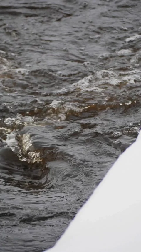 Close-up Vertical View of Dark Rushing River Water with White Foam and Snowy Edg Stock Footage 326216373