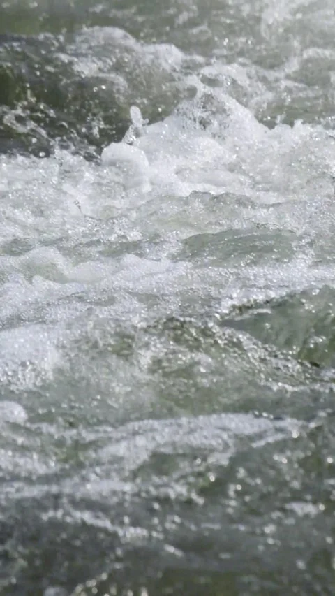 Close up vertical view of the ripples of a fast flowing mountain river Stock Footage 320983447