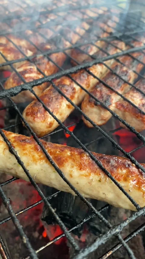 Close up, vertical view of sausages sizzling on grill Stock Footage 308280526