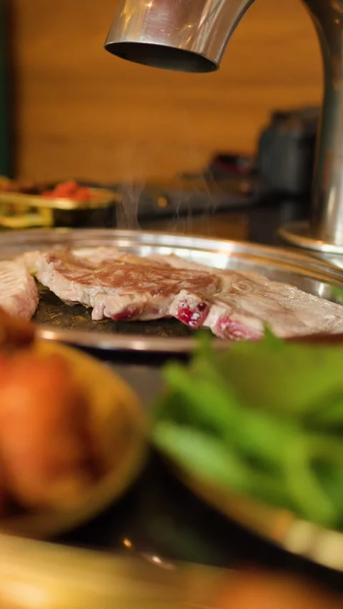 Close Up Vertical View of Sizzling Meat on Tabletop Grill Stockbeeldmateriaal 327944756