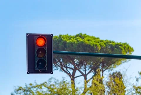 Close up of vertically mounted hanging black traffic light with red signal Foto stock
