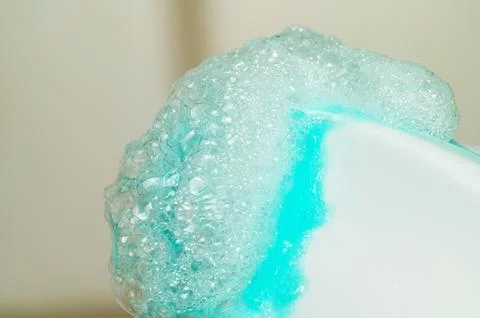 Close-up of vibrant blue liquid creating a frothy foam with many small bubble Stock Photos