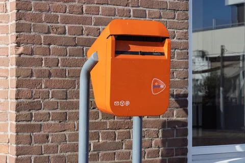 A close-up of a vibrant orange PostNL mailbox, Stock Photos