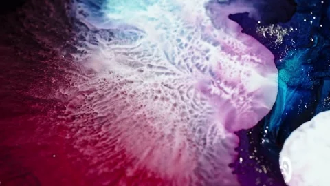 Close-up of vibrant red and blue ink diffusing in water, creating an Stock Footage 265184779