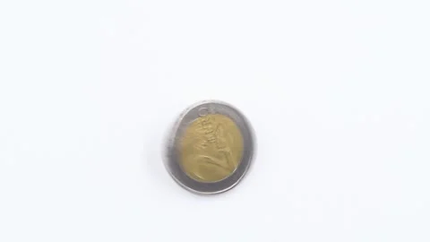 Close-up video of a 2 euro coin rolling on a white background, detailed macro Stock Footage 329254256