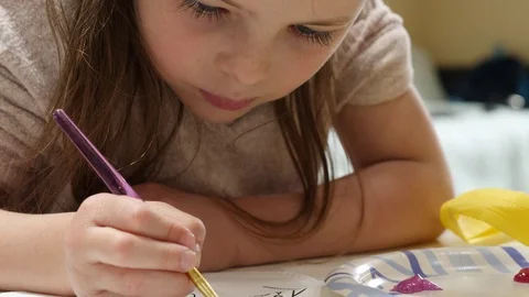 Close up video as 6 year old girl is painting a picture Stock Footage 130144412