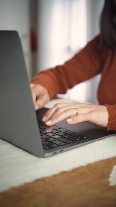 Close-up video of an anonymous woman’s hands using a laptop in an office, highli Stock Footage 346327459