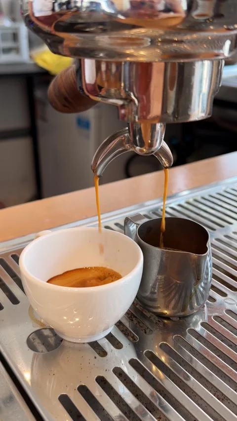 Close-up video of a barista extracting fresh espresso into cups from a Stock Footage 346691133