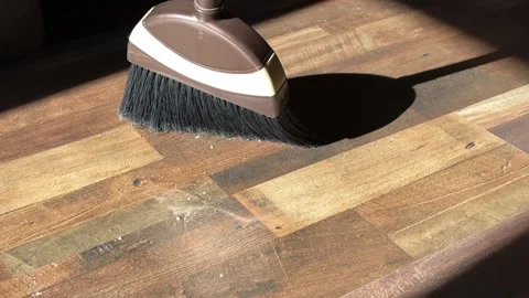 Close-up video of a broom sweeping dust and dirt from a wooden floor Stock Footage 317752740