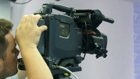 Close-up of a video camera during a television broadcast. The cameraman adjus Stock Footage 93830865