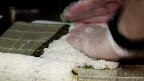 Close-up video of chef in black gloves putting rice into sushi Stock Footage 285249480
