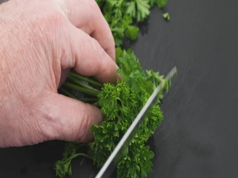 Close video of chopping curly parsley on a stone cutting board. Stock Footage